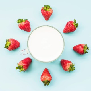 Overhead view strawberries milk blue backdrop