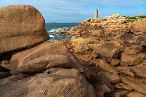 The rocks of the pink granite coast Cote de Granit Rose and the lighthouse Phare de Ploumanac'h near Ploumanac'h