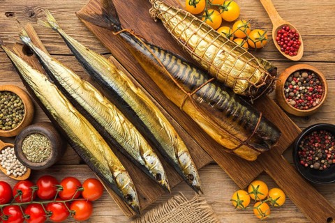 Smoked fishes wooden table flat lay