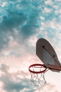 Low angle view basketball hoop against cloudy sky