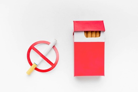 Stop smoking sign beside pack cigarettes