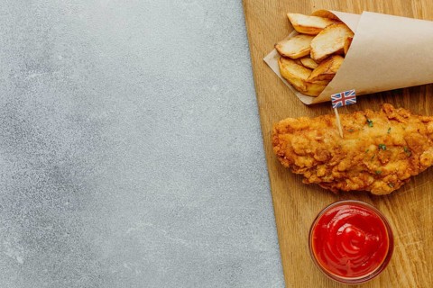 Top view fish chips paper wrap with ketchup copy space