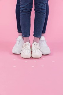 Man woman legs jeans sneakers near decorative hearts