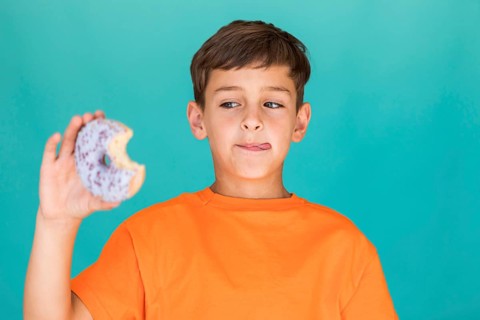 Boy looking delicious glazed doughnut