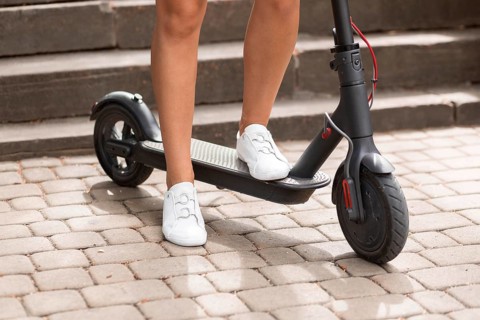 Front view woman riding electric scooter