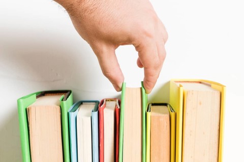 Person choosing book from shelf