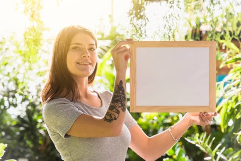 Attractive happy woman holding frame plants