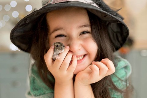 Close up view cute little girl holding hamster