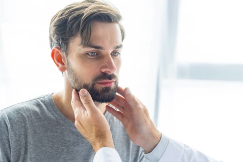 Crop doctor touching lymph nodes young man