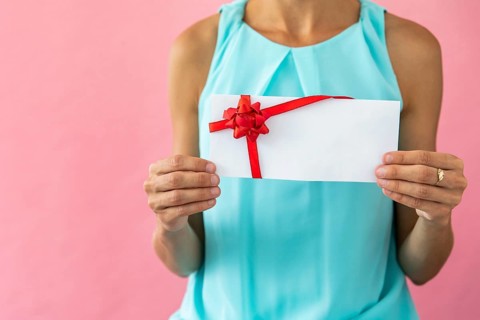 Woman holding envelope with ribbon