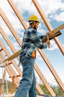 Construction worker with hard hat building roof house