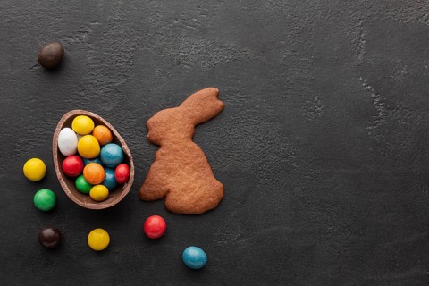 Chocolate easter egg filled with colorful candy bunny shaped cookie