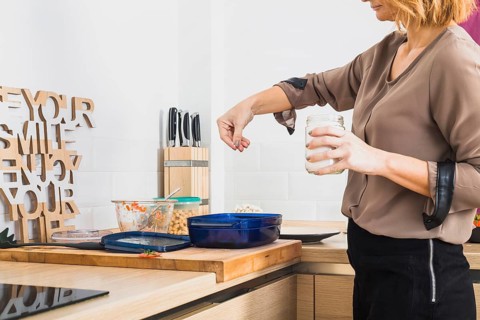 Female standing kitchen salting food