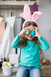 Cute girl bunny ears holding colored eggs eyes