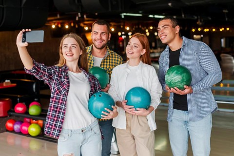 Friends holding colorful bowling balls