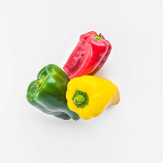 High angle view green yellow red bell peppers white background