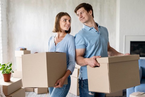 Couple holding boxes moving out day