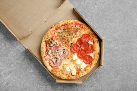 Top view of classic pizza four seasons in takeaway cardboard box