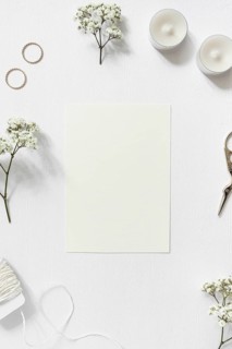 Blank card surrounded with gypsophila wedding rings string scissor white background