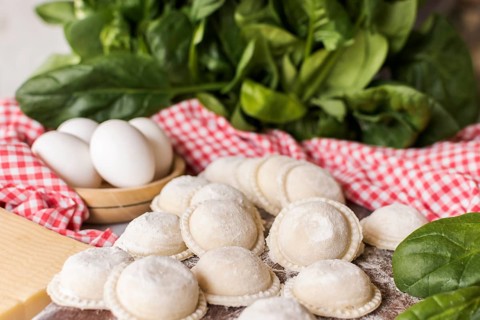 Circular raw ravioli with spinach eggs