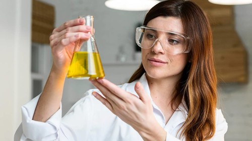 Female scientist with safety glasses holding test tube