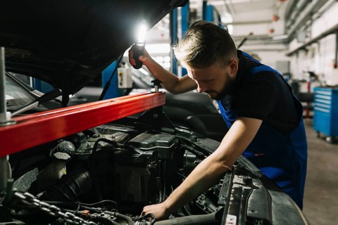 Auto mechanic looking car s engine room
