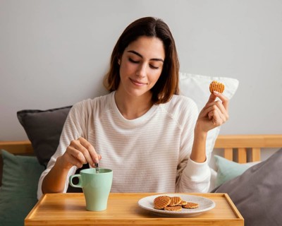 Front view woman eating having coffee home