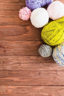Multi colored ball yarns wooden background