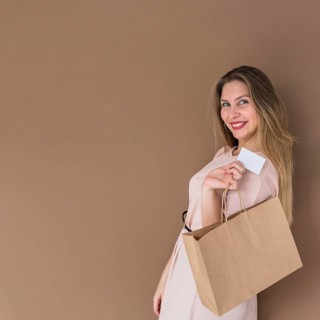 Happy woman standing with shopping bag credit card