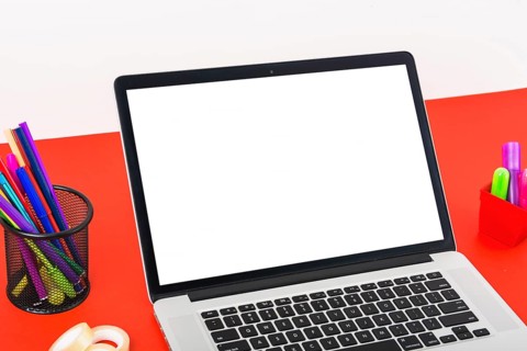 Close up modern laptop with blank white screen red table