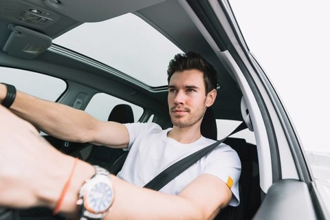 Close up young man driving car