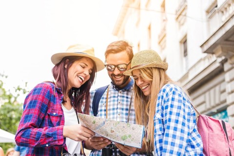 Group happy male female hikers looking location map