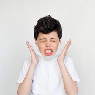 Front view young boy sneezing