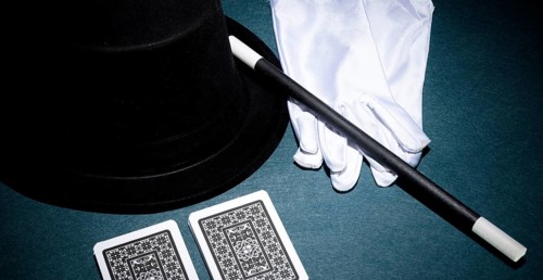 Panoramic view playing card white gloves top hat magic wand green background