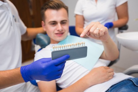 Patient pointing teeth with dentist