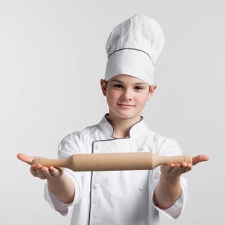Portrait young master chef holding rolling pin