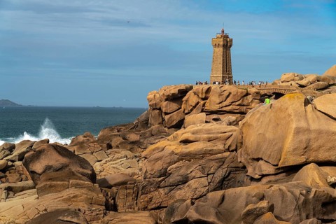 The rocks of the pink granite coast Cote de Granit Rose and the lighthouse Phare de Ploumanac'h near Ploumanac'h