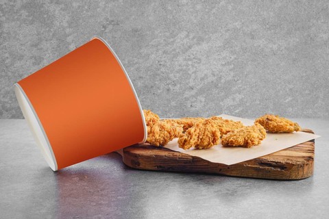 Deep fried chicken wings basket in breading scattered on parchment paper