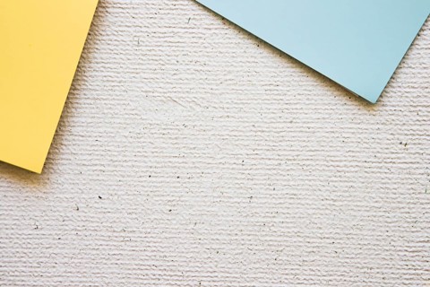 Overhead view grey yellow cardboard papers concrete background