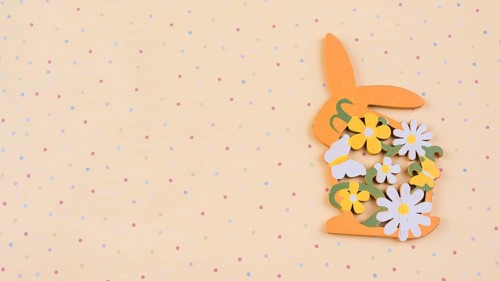 Wooden rabbit with flowers beige table