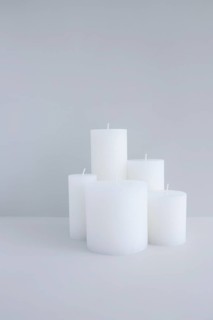 Close up white candles against grey background
