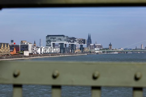 View of the city of Cologne and the Rhine through the railing of the South Bridge with Rheinauhafen