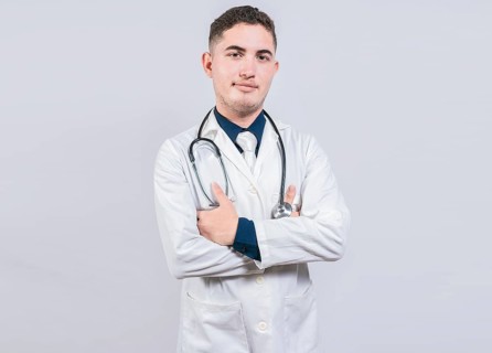 Portrait of handsome doctor with arms crossed isolated. Latin doctor with crossed arms on white background