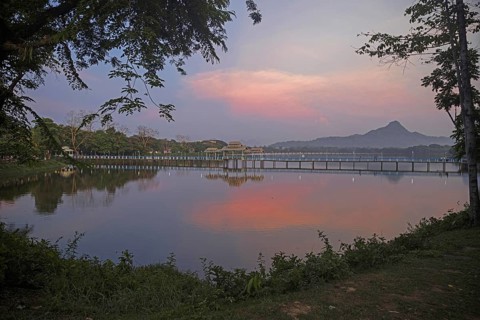 Wooden bridge over Kan Thar Yar Lake at sunset