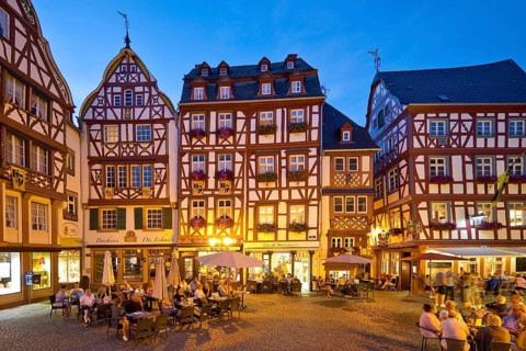 Gabled half-timbered houses on the busy medieval market square in the evening