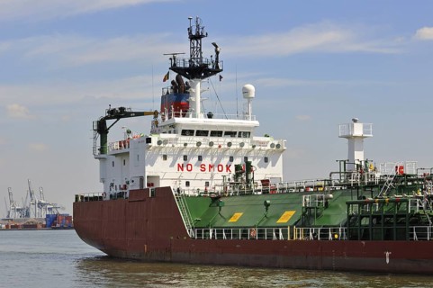 Red gas tanker sailing into dock of the Antwerp harbour