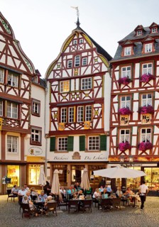 Gabled half-timbered houses on the busy medieval market square in the evening
