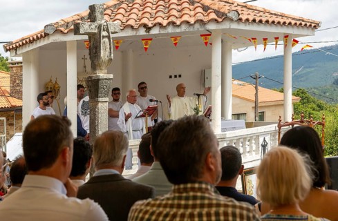 Village fiesta Catholic priest praying at outdoor mass service