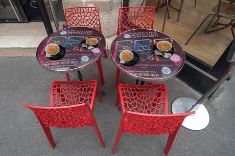 Espressos on bistro tables in front of a cafe