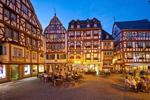 Gabled half-timbered houses on the busy medieval market square in the evening